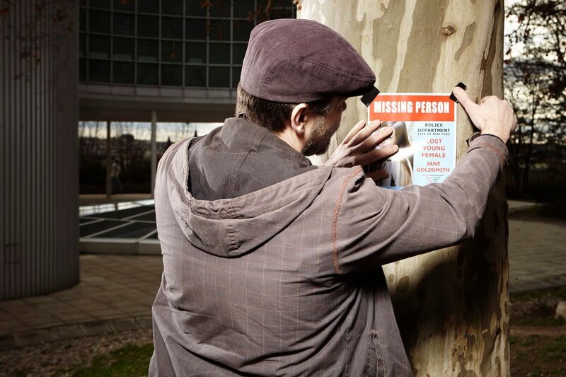 Police detective hanging up posters with information about missing person. – Bild: David äpidlen/​Couperfield