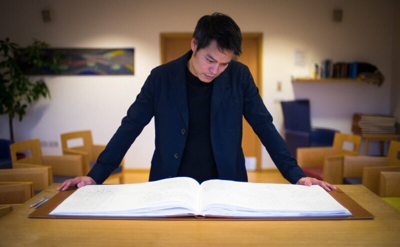 Intensivmediziner Dr. Kevin Fong, der durch Dokumentation führt, betrachtet das „Buch der Erinnerung“ im Londoner St Christopher’s Hospiz. – Bild: BBC Studios/​Toby Macdonald