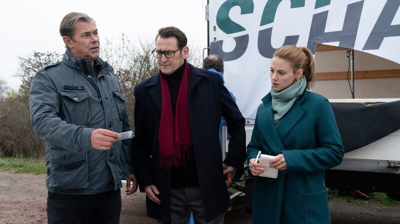Der Lkw-Fahrer Stefan Buschke wurde erstochen auf einem Rastplatz neben seinem Fahrzeug gefunden. Am Tatort nehmen Finn (Sven Martinek), Lars (Ingo Naujoks) und Nina (Julia E. Lenska, v.l.n.r.) die Frachtpapiere genauer unter die Lupe. – Bild: ARD/​Georges Pauly