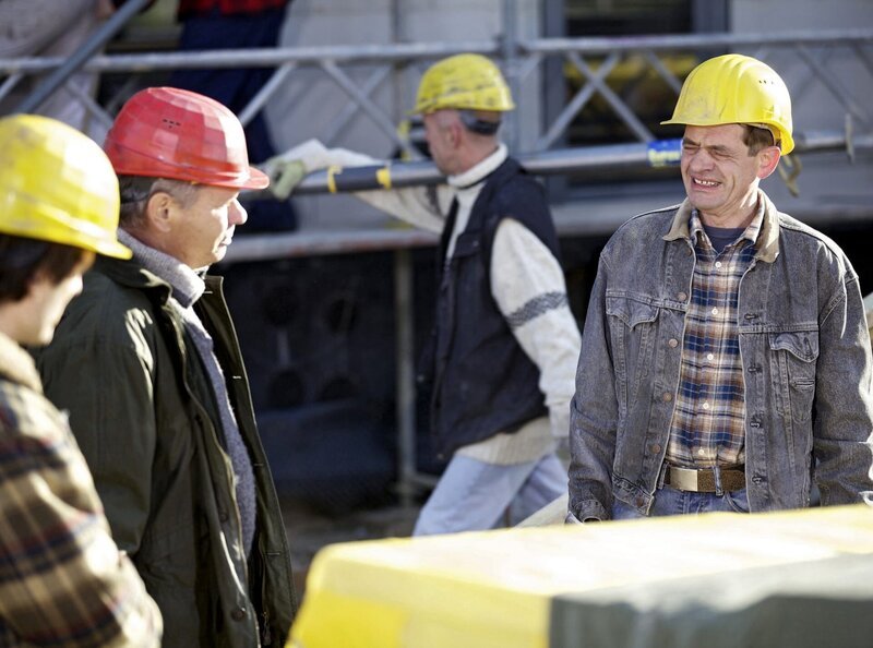 Auf der Baustelle herrscht angespannte Stimmung. Bauleiter Volker Angermann (Ronald Nitschke, 2.v.li.) ärgert sich darüber, dass eine falsche Lieferung angekommen ist und die Liefereinfahrt nicht frei ist. Sein Vorarbeiter und langjähriger Freund Mario Goepfert (Henning Peker, re.) soll das Auto wegfahren obwohl er über Sehbeschwerden klagt. – Bild: MDR/​MDR/​Wernicke