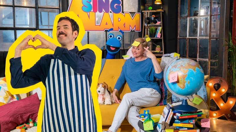 Singa und das SingDing grübeln über ihre Lieblingsdinge. Johannes Stankowskis Lieblingsessen steht auf jeden Fall fest: Reibekuchen! Die backt er bei SingAlarm und widmet ihnen direkt einen Song. – Bild: ZDF/​Tim Bornemann