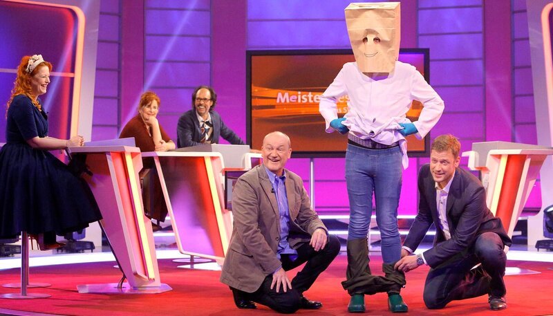 Um welche Frage es hier geht – der „Mann mit den grünen Handschuhen“ hilft bei der Aufklärung. v.li.: Enie van de Meiklokjes, Alice Hoffmann, Christoph Sonntag, Bodo Bach, der Mann mit den grünen Handschuhen und Florian Weber. – Bild: SWR/​Peter A. Schmidt
