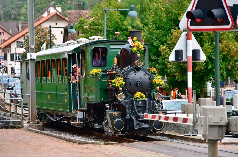 Die reich geschmückte Lok an einem der vielen Bahnübergänge. Die Strecke soll in eine meterspurige Strecke umgewandelt werden. – Bild: SWR