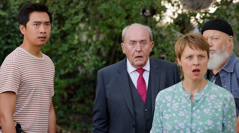 Plocher (Michael Prelle, 3.v.r.), Vicky Adam (Katja Danowski, 2.v.r.), Reinhard Bielefelder (Bill Mockridge, r.) und Hui Ko (Aaron Le, l.) sehen erstaunt, Klaus Schmitz beim Trampolinspringen zu. – Bild: ARD/​Tom Trambow