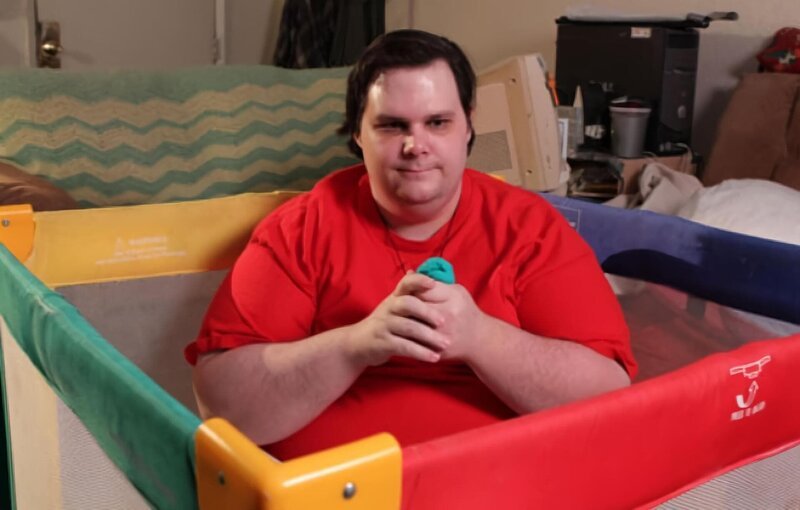 Stanley Thornton holds some play dough in his crib. – Bild: National Geographic Society