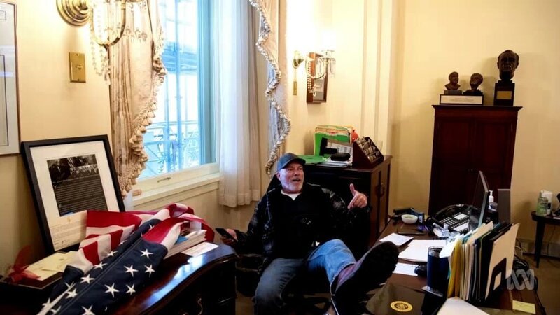 Eines der bekanntesten Bilder vom 6. Januar: Richard Barnett aus Arkansas fläzt sich am Schreibtisch von House Speaker Nancy Pelosi. Er wurde vom FBI festgenommen. – Bild: Journeyman Pictures/​ WeltN24 GmbH
