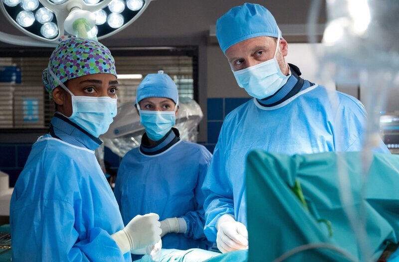 Gemeinsam operieren Dr. Emma Jahn (Elisa Agbaglah, l.) und Dr. Kai Hoffmann (Julian Weigend, r.) das Mädchen Pia Strehlke (mit Komparsin, M.). – Bild: ARD/​Jens-Ulrich Koch