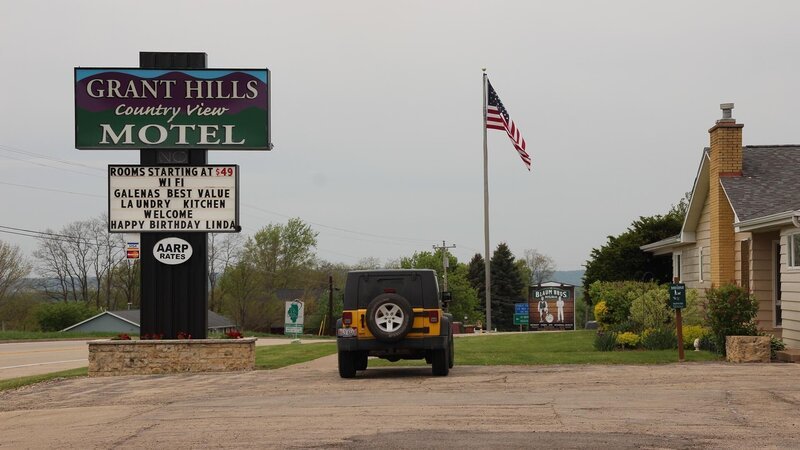 The sign for the Grant Hills Motel looms above the sign for Blaum Bros. Distilling Co. in Galena, Illinois. – Bild: The Travel Channel, L.L.C.