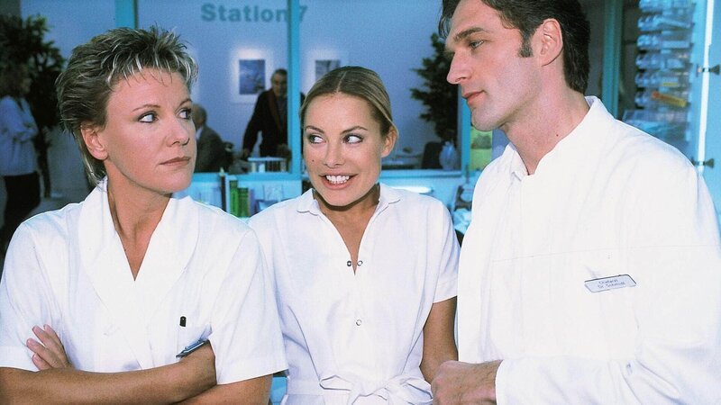 Nikola (Mariele Millowitsch, l.) traut ihren Ohren nicht, als Dr. Schmidt (Walter Sittler) in aller Öffentlichkeit Mariannes (Xenia Seeberg) große Fähigkeiten lobt. – Bild: RTL /​ Guido Engels