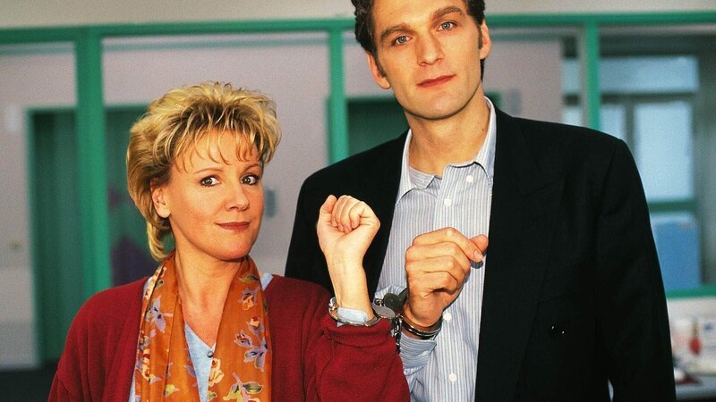 Schwester Nikola (Mariele Millowitsch) und Dr. Schmidt (Walter Sittler) in Handschellen aneinander gekettet: Die beiden demonstrieren, was wahre Teamarbeit bedeutet. – Bild: Foto: RTL