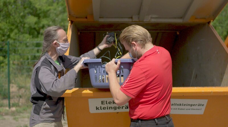 Am Wertstoffhof: Heinrich Jung (l) von der „Blitzblume“ auf der Suche nach alten Geräten, die noch zu gebrauchen sind. Seine These: Neun von zehn Dingen, die im Müll landen, wären eigentlich mit wenig Aufwand noch zu retten. – Bild: BR/WDR, privat, Heinrich Jung Am Wertstoffhof: Heinrich Jung (l) von der „Blitzblume“ auf der Suche nach alten Geräten, die noch zu gebrauchen sind. Seine These: Neun von zehn Dingen, die im Müll landen, wären eigentlich mit wenig Aufwand noch zu retten. – Bild: BR/WDR, privat, Heinrich Jung