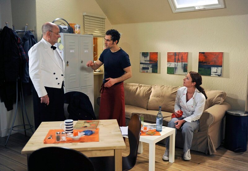 ARD ROTE ROSEN FOLGE 1003, Alfred (Rolf Nagel, l.) schreckt Nils (Gabriel Merz, M.) und Carla (Maria Fuchs, r.) mit der Nachricht auf, dass der Sternekritiker schon an diesem Tag kommt. – Bild: Nicole Manthey, ARD