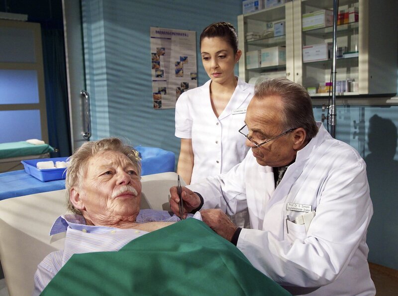 Gunnar Sundberg, ein erfolgreicher Krimiautor, kommt mit einem gebrochenen Arm in die Sachsenklinik. Während Prof. Gernot Simoni und Schwester Arzu Ritter ihn untersuchen, hat Prof. Simoni das Gefühl, dass der Patient ihm etwas verschweigt. – Bild: MDR/​Rudolf K. Wernicke