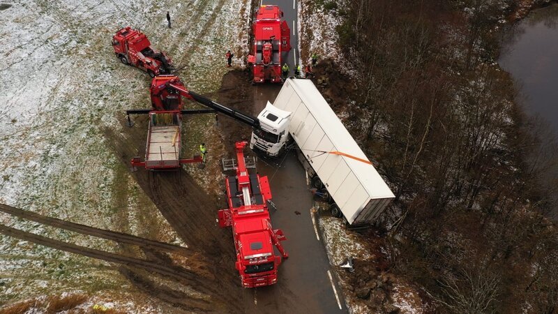 Four rescue trucks working to pull a truck and trailer. – Bild: National Geographic