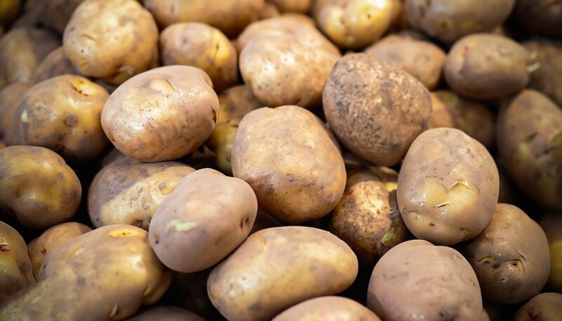 Stockfotografie viele Kartoffeln auf dem lokalen Markt. Zwiebeln hautnah. Selektives Fokusbild. – Bild: depositphotos