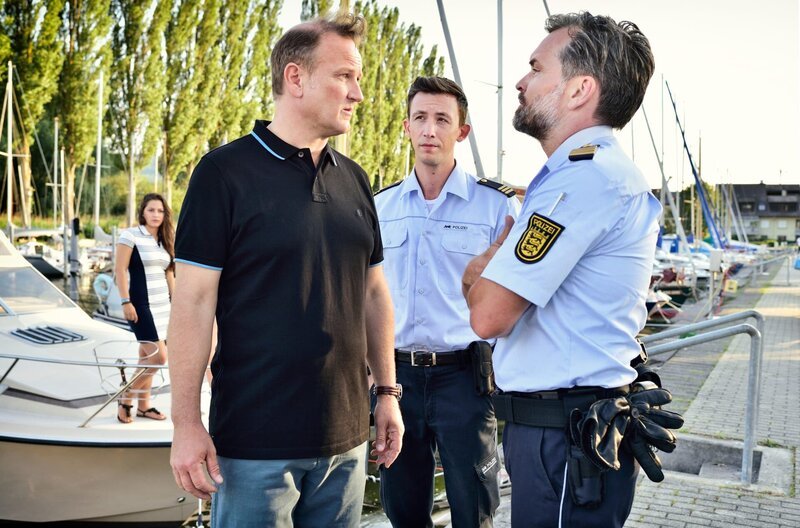 Pirmin Spitznagel und Andreas Rambach setzen Andreas Holler, den Vorsitzenden des Segelclubs, unter Druck. – Bild: ARD/​SWR/​Patrick Pfeiffer