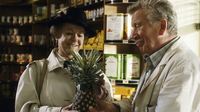 Vadder Haack (Heinz Reincke) hat den richtigen Riecher und schenkt seiner Fanny (Enzi Fuchs) eine Ananas. Fanny ist überwältigt. – Bild: ZDF/​Aspekt Telefilm-Produktion GmbH