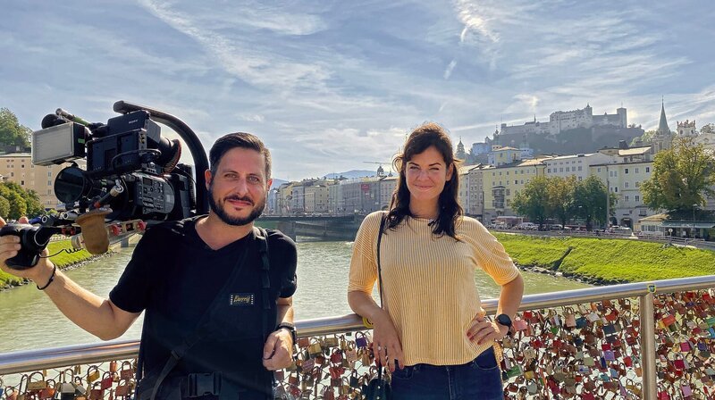 Lisa und Davide auf dem Makartsteg, im Hintergrund: die Festung Hohensalzburg. – Bild: WDR/​M.E. Works TV/​Britta Ebel