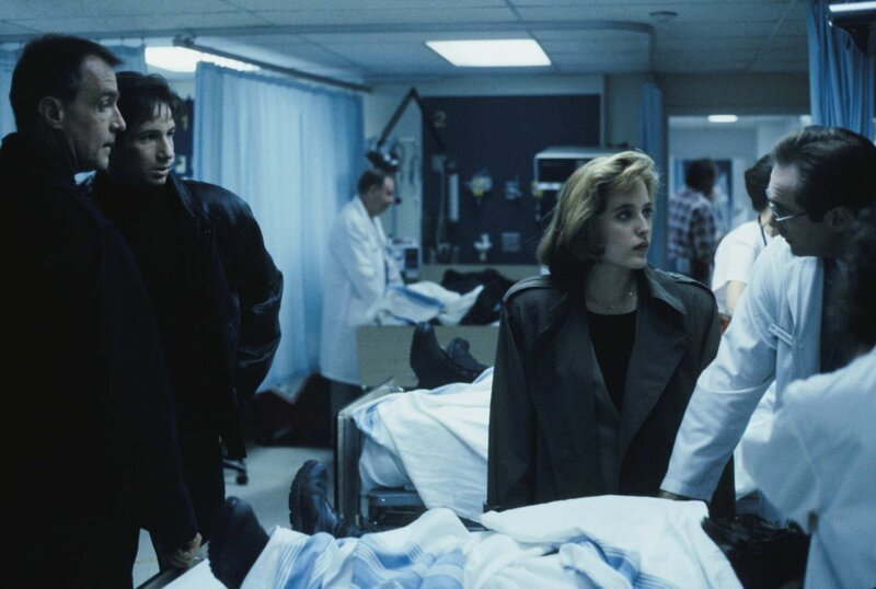 Mulder (David Duchovny, 2.v.l.) und Scully (Gillian Anderson, 2.v.r.) vermuten, dass die Bewohner, die ins Krankenhaus eingeliefert wurden, mit außerirdischen Lebensformen in Berührung kamen. Doch können sie davon auch Colonel Calvin Henderson (Marshall Bell, l.) und Dr. Oppenheim (William McDonald, r.) überzeugen? – Bild: port.hu