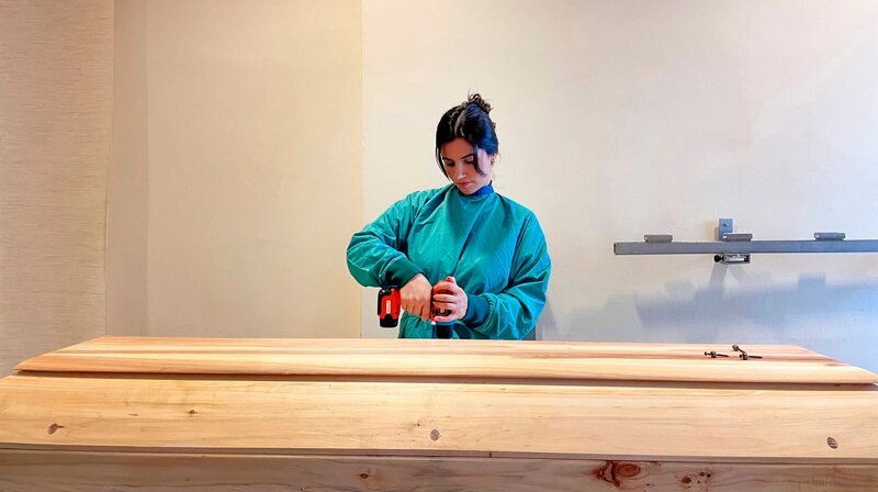 Seren bei der Arbeit im Bestattungsinstitut. Sie bereitet einen Sarg für eine Beisetzung vor. – Bild: NDR/​Yasemin Ergin