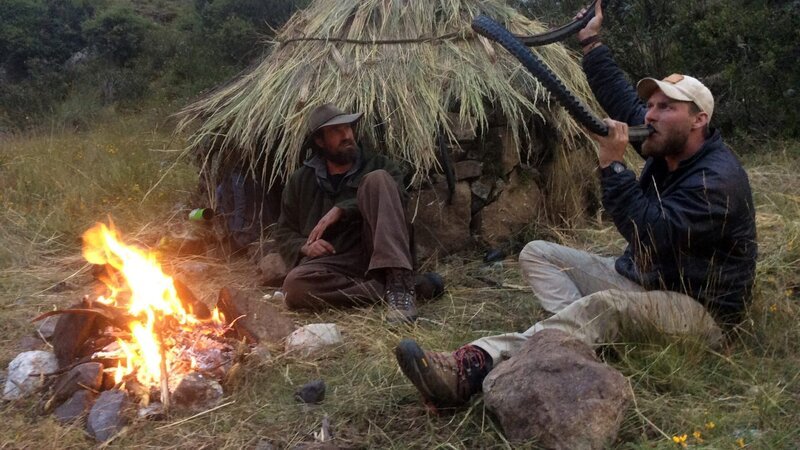 Fire burning while Josh James looks at Grady Powell drinking from tire. – Bild: Discovery Communications, Inc.