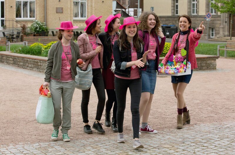 Eine Gruppe junger Frauen (Komparserie) kommt gut gelaunt zum Reisebus. – Bild: ARD/​Volker Roloff