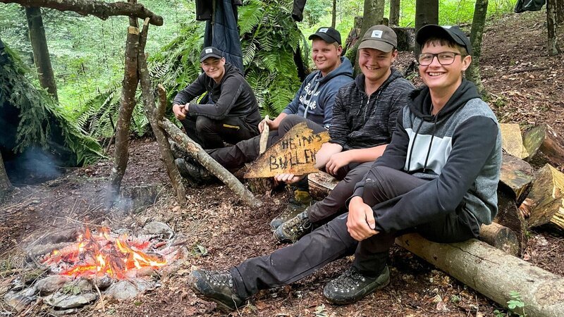 Die Gebrüder Heim haben ihr Camp im Wald zu einem halben Dörfchen ausgebaut. v.l.: Fabio, Michael, Silvan und Patrick Heim – Bild: SRF