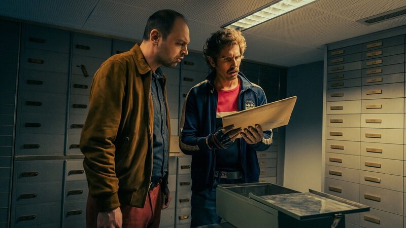 Tschugger Staffel 3 2023 Regie: David Constantin, Johannes Bachmann Drehbuch: David Constantin, Johannes Bachmann, Jelena Vujović, Fiona Schreier, Pascal Glatz, Christian Wehrlin Produktion: Shining Film AG Folge 5 Motiv 1 Fördern erstaunliche Dokumente zu Tage: Dragan Vujic als Pirmin, Cavid Constantin als Bax. – Bild: SRF/​Dominic Steinmann