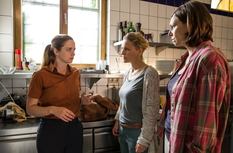 Paula Sprenger (Sarina Radomski, li.) arbeitet undecover im alternativen Café. Katja Reuter (Caroline Scholze, mi.) und Conny Petzold (Charlotte Böhning, re.) überraschen sie in der Küche der grünen Insel. – Bild: ARD/​Daniela Incoronato