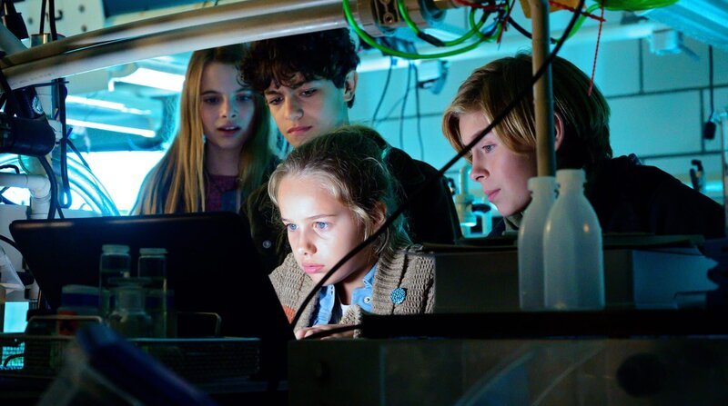 Alice (Emilia), Tarun (Casper), Clari (Charlotte) und Jonny (Leander) versuchen, im Labor des Instituts für Meeresforschung zu verstehen, woran Jaswinder gerade arbeitet. – Bild: NDR/Letterbox/Aidan Monaghan Alice (Emilia), Tarun (Casper), Clari (Charlotte) und Jonny (Leander) versuchen, im Labor des Instituts für Meeresforschung zu verstehen, woran Jaswinder gerade arbeitet. – Bild: NDR/Letterbox/Aidan Monaghan