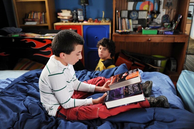 Brick (Atticus Shaffer, l.) freut sich riesig auf das letzte Buch seiner Lieblingsbuchreihe. Doch als Axl (Charlie McDermott, r.) ihm aus Rache das Ende verrät, bricht für ihn eine Welt zusammen. Unterdessen befürchtet Frankie, dass Mike sie nach 20 Jahren Ehe nicht mehr genug schätzt. – Bild: Warner Brothers
