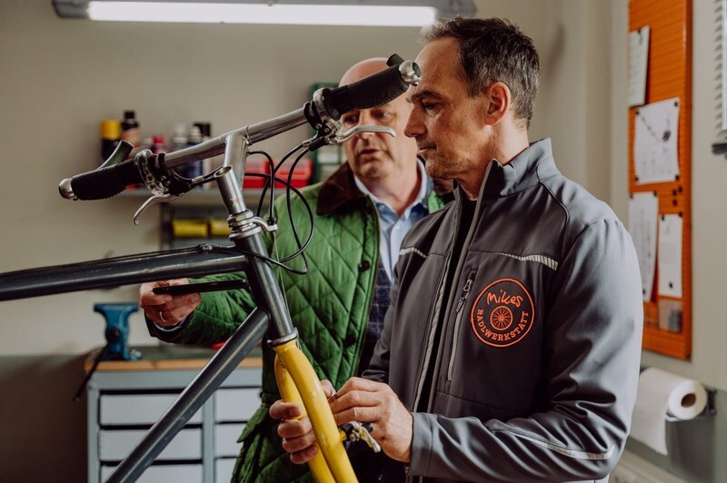 Mike spricht mit Hubert in seiner Fahrradwerkstatt über den Streit mit Annalena. – Bild: Nadya Jakobs /​ BR