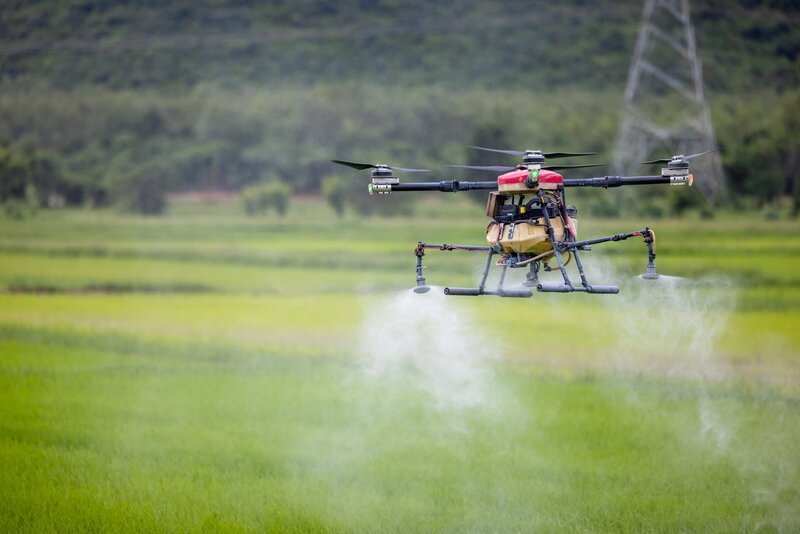 Landwirtschaftliche Drohnen gleiten über Reisfelder und versprühen Dünger. – Bild: Depositphotos /​ tongpatong