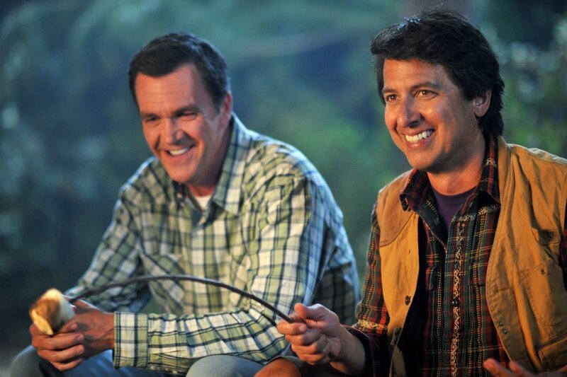Ein Campingausflug der Familie Heck endet in Streitereien und versetzen Mike (Neil Flynn, l.) und Frankie zurück in die Vergangenheit, als ihre Flitterwochen durch Nicky Kohlbrenner (Ray Romano, r.), Mikes altem Schulfreund, auf den Kopf gestellt worden waren … – Bild: HBOH