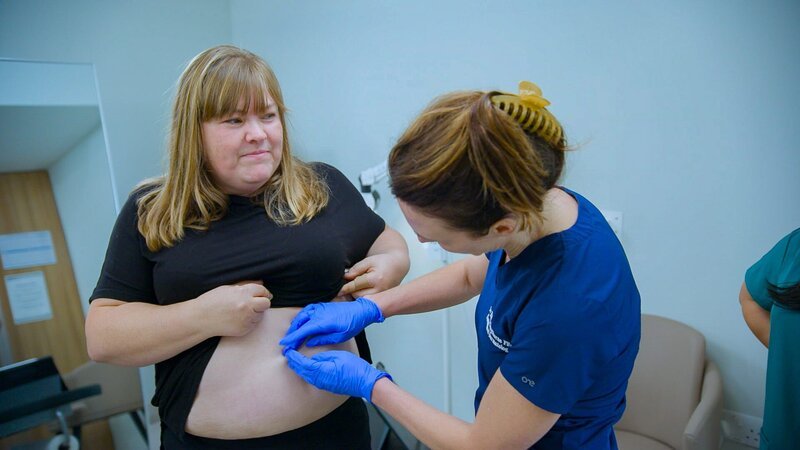 Medium Shot of Dr Emma examining Raelene’s Lipoma on her stomach – Bild: Warner Bros. Discovery, Inc.