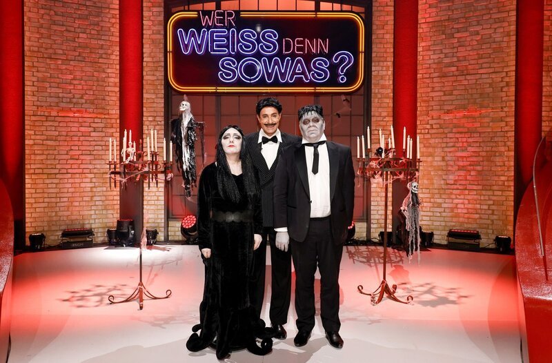 Moderator Kai Pflaume (M.) und seine Rateteam-Kapitäne Bernhard Hoëcker (l.) und Elton (r.), verkleidet als Addams-Familiy, begrüßen in diesem Halloween-Special Fernsehmoderator Harry Wijnvoord und Fernsehmoderatorin Marijke Amado. – Bild: ARD/​Morris Mac Matzen