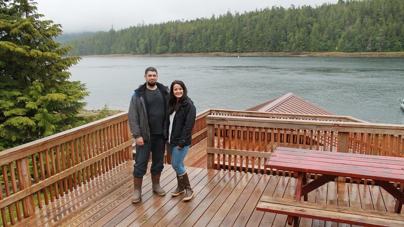 Adam and Autumn Bremer, standing on deck MS, at Gravina Island house, complete with multiple decks, facing water, near Ketchikan, Alaska, as seen on Great American Country’s Living Alaska – Bild: Great American Country/​Scripps Networks, LLC.
