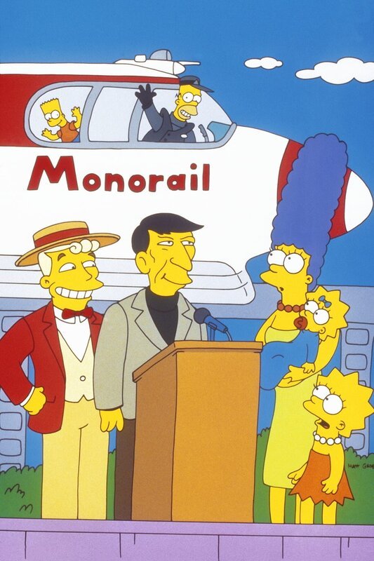Die Einschienenbahn wird von Mr. Lanley (l.) und Leonard Nimoy (2.v.l.) eingeweiht. Marge (3.v.r.), Lisa (r.), Bart (oben l.) und Maggie (2.v.r.) sind mächtig stolz auf Homer, der den Job als Zugführer angenommen hat. – Bild: Twenthieth Century Fox Film Corporation