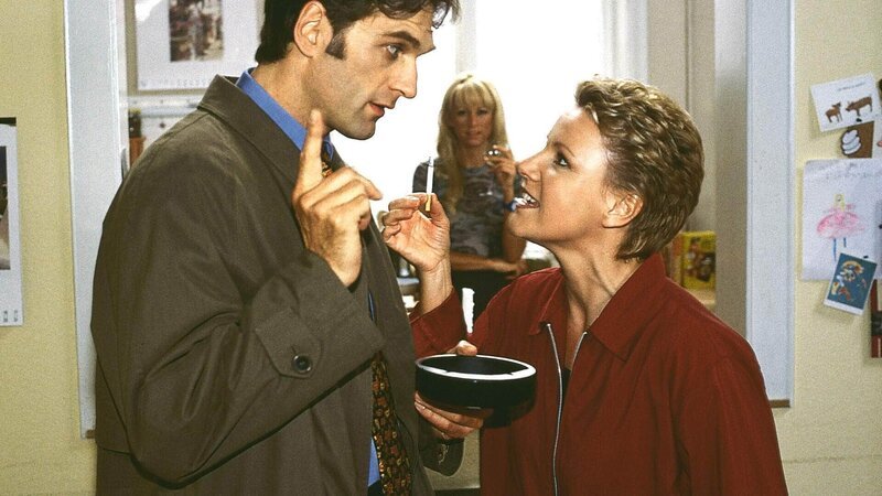 Dr. Schmidt (Walter Sittler) erklärt Nikola (Mariele Millowitsch, r.), dass er erfahren hat, dass Hannes schwul ist (hinten Jenny Elvers). – Bild: RTL /​ Guido Engels