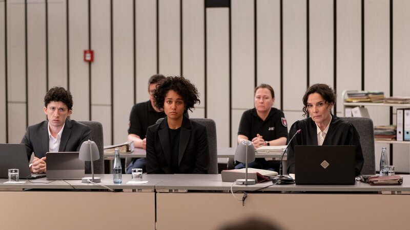 Sängerin Liz Jordan (Larissa Sirah Herden, M.) wird auf der Anklagebank vertreten und begleitet von Rechtsanwältin Anna Conti (Désirée Nosbusch, r.) und deren Assistenten und Schützling Carlo (Maximilian Mundt, l.). – Bild: Georges Pauly