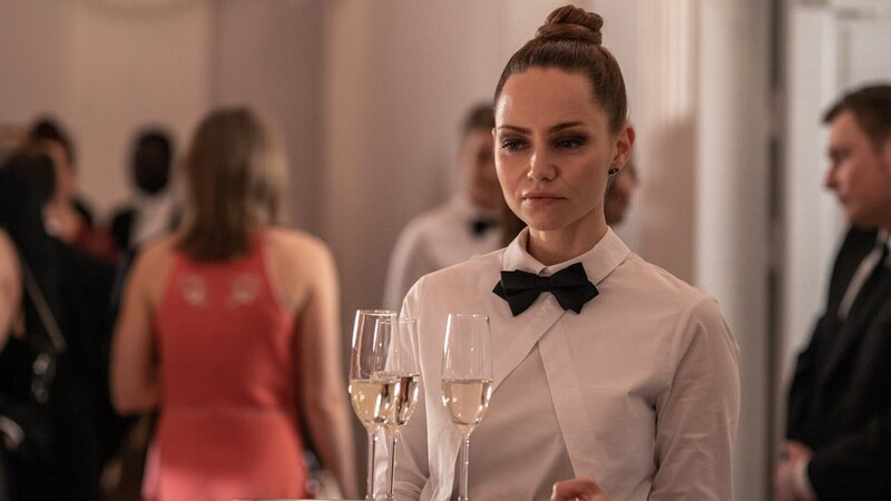 Auch Raisa (Mirtel Pohla) gehört zu der Gruppe, die den Terroranschlag auf den Präsidentenpalast verübt. Sie verschafft sich als Catering-Mitarbeiterin Zugang zu dem Festakt. – Bild: Cinematic Productions S Oy 2021