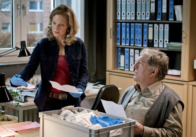 Schroeter (Veit Stübner, r.) und Staatsanwältin Elke Rasmussen (Tessa Mittelstaedt, l.) werten Beweismittel aus. – Bild: MDR/​Georges Pauly