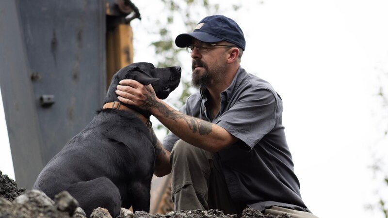 Ein Besatzungsmitglied streichelt einen Hund. – Bild: Discovery Channel /​ Discover Images. /​ Warner Bros. Discovery, Inc. or its subsidiaries and affiliates.
