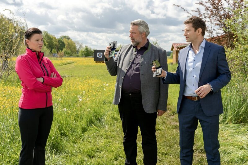 Die Kommissare Stadler (Dieter Fischer, M.) und Hansen (Igor Jefti , r.) befragen die Übungsleiterin des Bogensportclubs Rosenheim, Lisa Pfaff (Tanja Hirner, l.) im Mordfall Arnd Schuster, denn das Opfer wurde mit einem Pfeil getötet. – Bild: ZDF/​Bojan Ritan