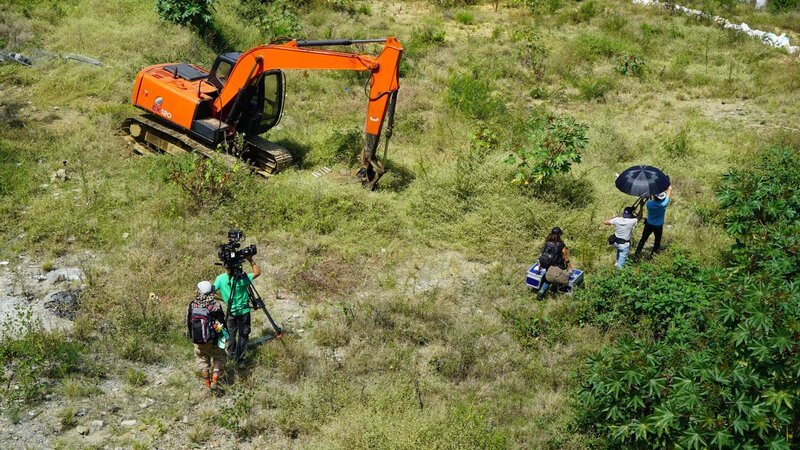 Crew begins to set up in an empty field in barrio Pablo Escobar. An excavator is ready to begin its work of digging up the property. – Bild: Discovery Channel /​ Discovery Communications