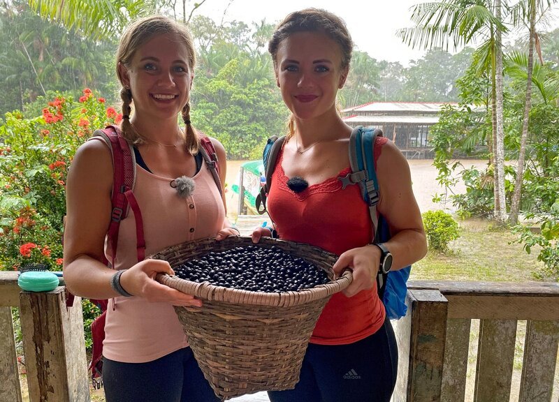 Die Passagierinnen Lisa Forster und Christine Spindler mit einem Korb voller Acai-Früchte bei ihrem Ausflug auf Ilha do Combù. – Bild: BR/​Bewegte Zeiten Filmproduktion GmbH/​Cornelia Schulze