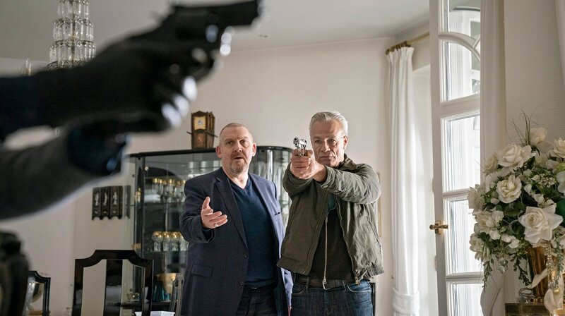 Mit gezogener Waffe: Die Kommissare Max Ballauf (Klaus J. Behrendt, r) und Freddy Schenk (Dietmar Bär, l) versuchen, einen Mord zu verhindern. – Bild: WDR/​Thomas Kost