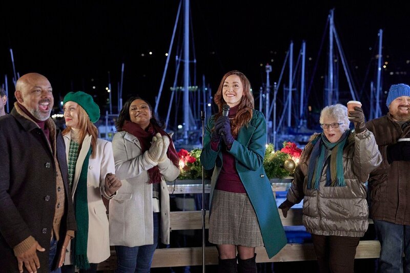 Christina (Sarah Power) erfährt, dass der Anlegeplatz am Pier, auf dem sich ihr Spielzeugladen befindet, abgerissen werden soll. Doch dann verliebt sie sich in den Sohn des Bauunternehmers. – Bild: Allister Foster /​ MMXXI Journey Productions Inc.