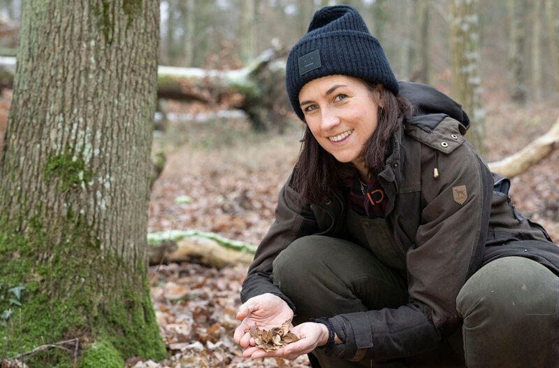 Zaneta Frankenfeld sammelt Bucheckern im Wald: Gemeinsam mit ihrem Mann Johannes betreibt sie eine Bucheckern-Manufaktur in der Eifel. – Bild: WDR/​Melanie Grande