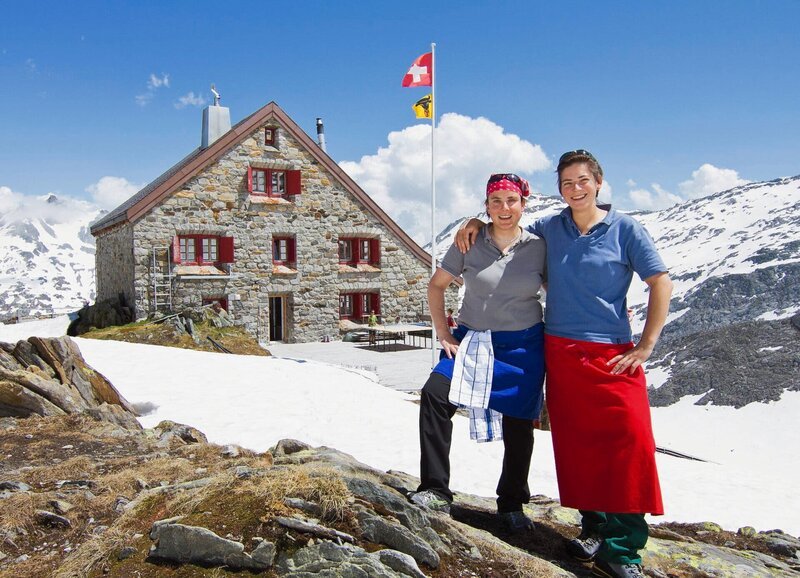 SF bi de Lüt Hüttengeschichten Folge 1 Die SAC-Hüttenwarte Jeanne Richenberger und Tanja Pfammater vor der Rotondohütte – Bild: SRF /​ Patrick Gautschy